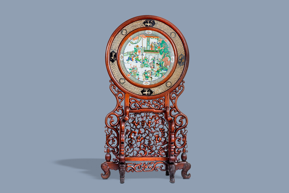 A massive Chinese carved wooden screen with a round famille verte plaque and polychrome lacquer, 19th C.