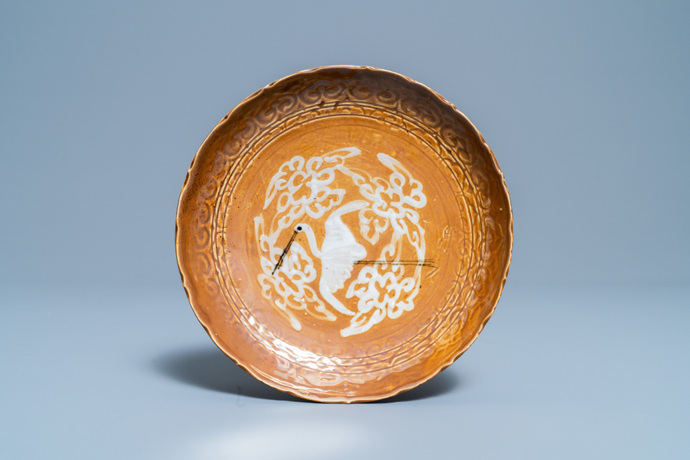 A rare Chinese slip-decorated brown-ground Swatow 'crane' plate, Ming