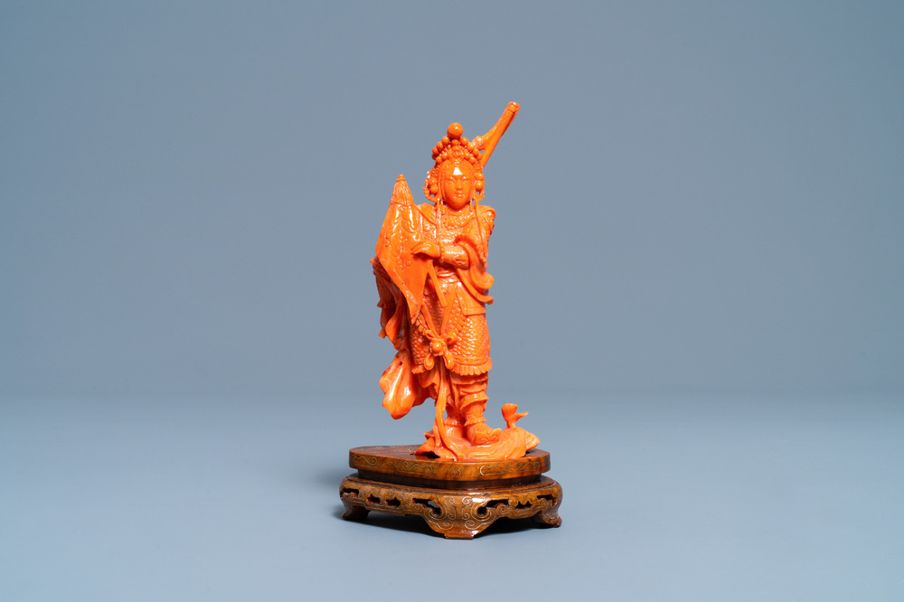 A Chinese carved red coral figure of a warrior holding a flag, 19/20th C.