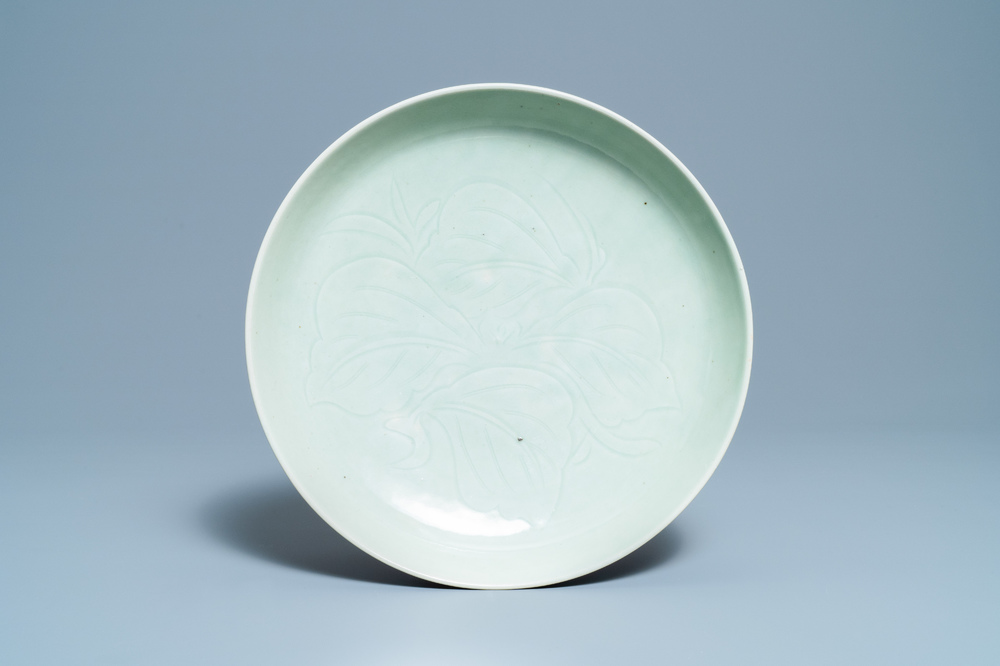 Een Chinese monochrome celadon schotel met onderglazuur floraal decor, 18/19e eeuw