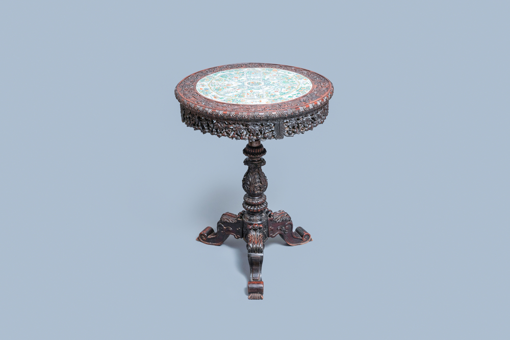 A Chinese carved wooden table with a large Canton famille verte plaque, 19th C.
