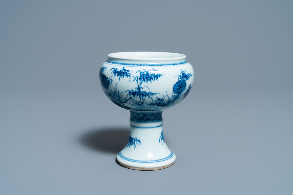 Een Chinese blauw-witte stem cup met floraal decor, Kangxi/Yongzheng