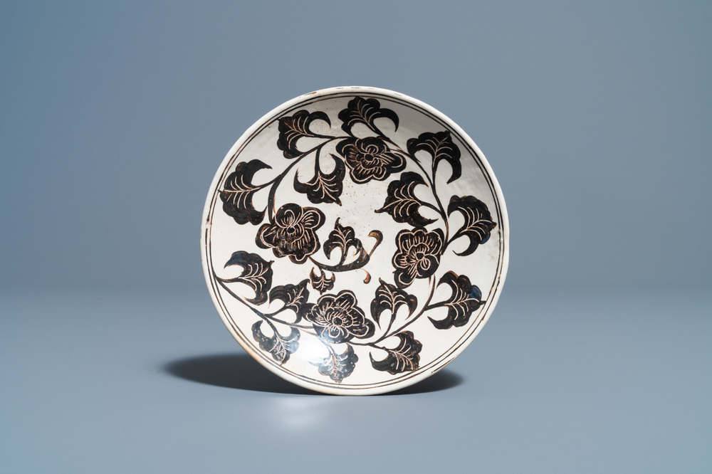 Een Chinees Cizhou bord met gekerfd floraal decor, Song/Ming