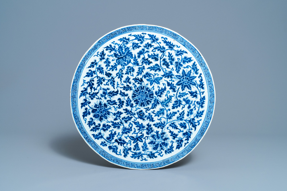 A large Chinese round blue and white plaque with floral design, 19th C.