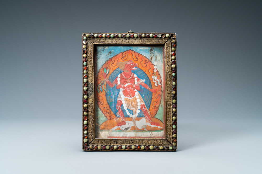A Tibetan thangka in inlaid gilt brass frame, 19th C.