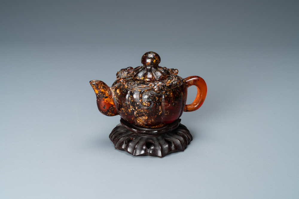 Une th&eacute;i&egrave;re couverte en ambre sculpt&eacute; sur socle en forme de lotus en bois sculpt&eacute;, 19&egrave;me