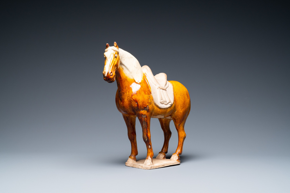 Un mod&egrave;le d'un cheval en terre cuite &agrave; gla&ccedil;ure ambre et beige, Chine, Tang