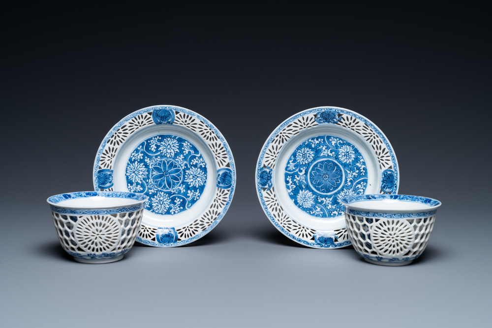 A pair of Chinese blue and white reticulated double-walled cups and saucers, Kangxi