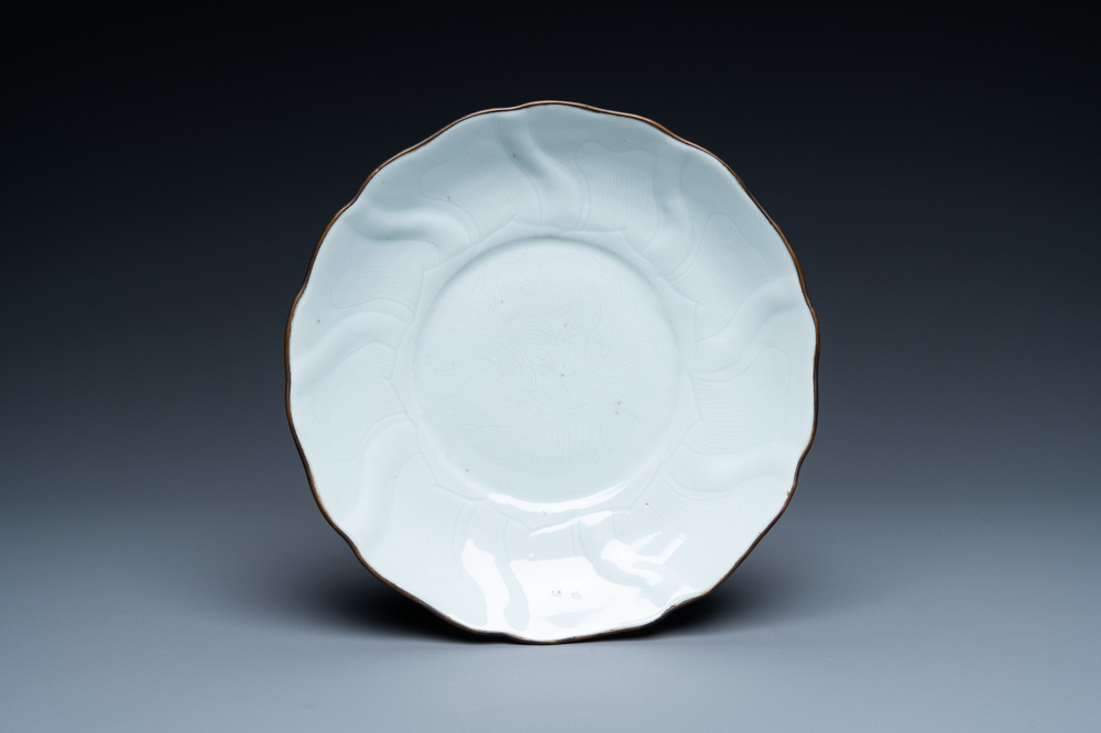 Een Chinees wit-geglazuurd bord met ingekrast lotusdecor, Xuande merk en periode