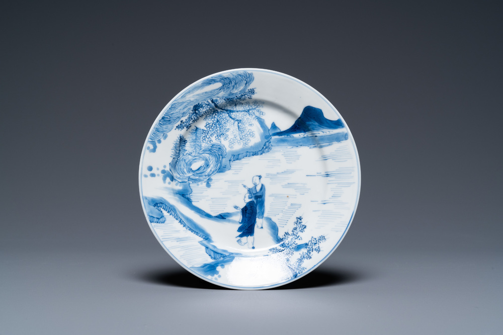 A Chinese blue and white plate with two men in a landscape, Kangxi