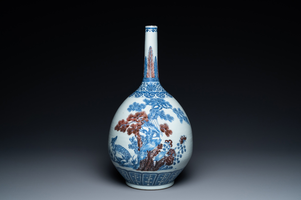 A Chinese blue, white and copper-red bottle vase with a deer and birds among blossoming branches, Daoguang