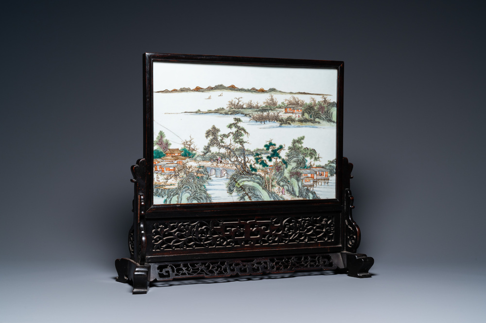 A Chinese rectangular famille rose 'landscape' plaque mounted in a wooden table screen, 19/20th C.