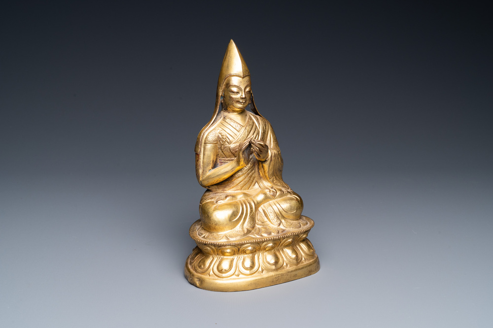 A Sino-Tibetan gilt bronze figure of a lamaic official or dignitary, probably 16th C.