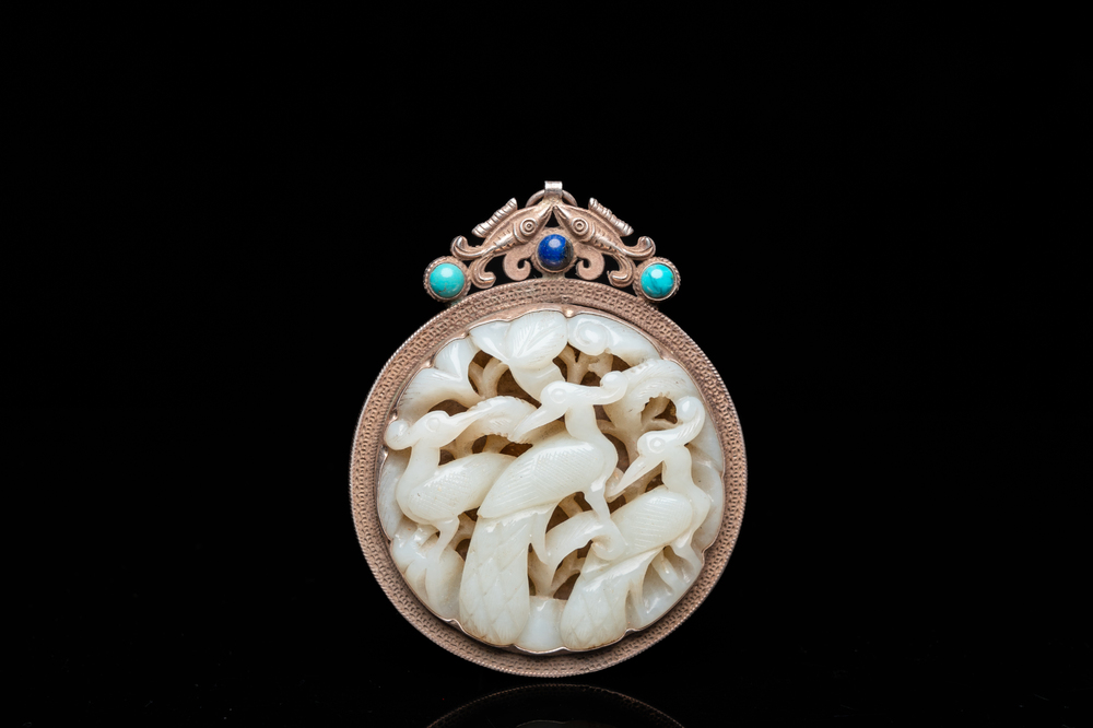 A Chinese reticulated jade 'three peacocks' carving in silver pendant, Qing
