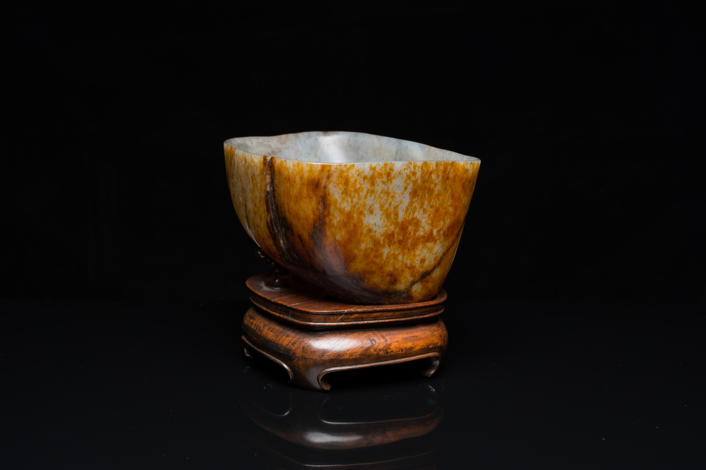 A Chinese hollowed jade libation cup on wooden stand, probably Qing