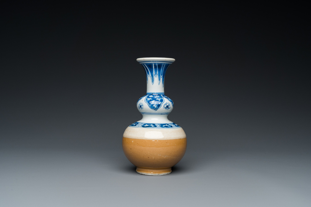 A Chinese blue and white double gourd vase with caf&eacute; au lait-ground base, Kangxi
