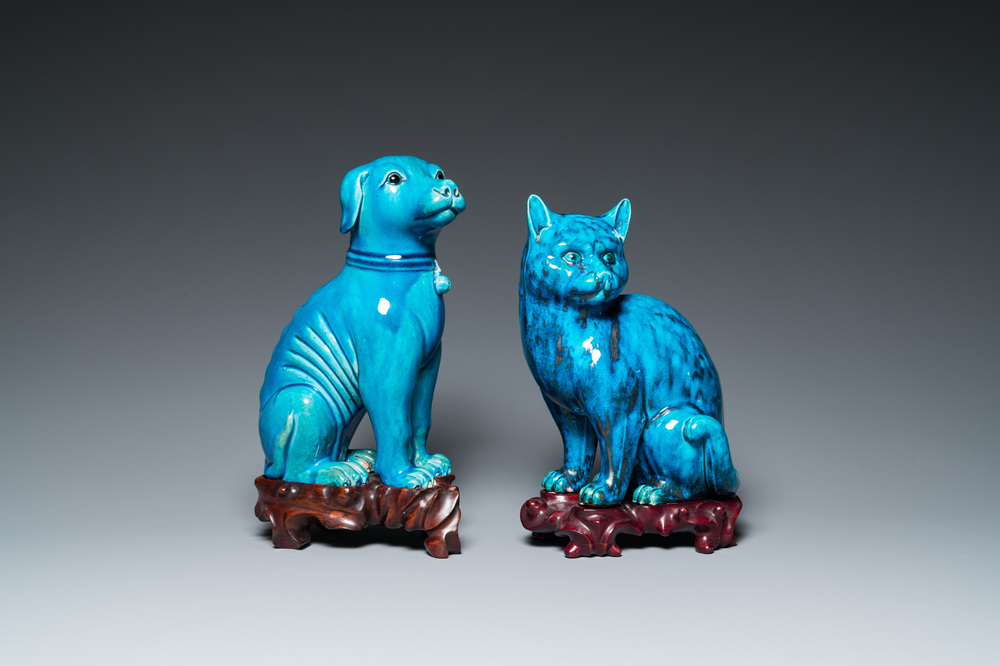 A Chinese turquoise-glazed cat and a dog on wooden stands, 19th C.
