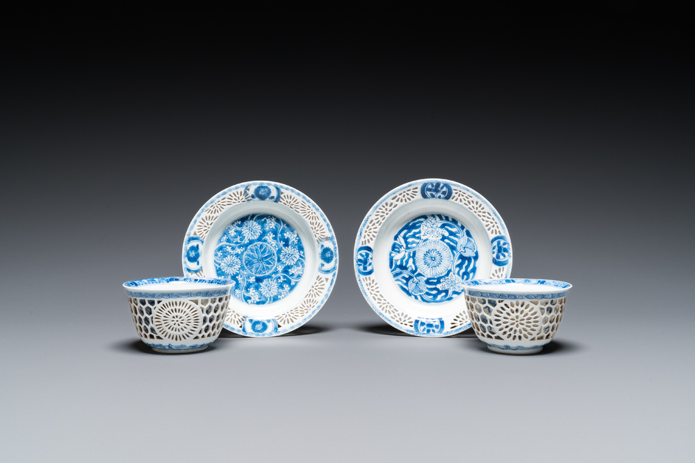 A pair of Chinese blue and white reticulated double-walled cups and saucers, Kangxi