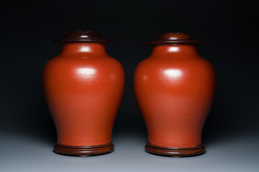 Een paar Chinese monochrome koraalrode vazen met houten deksels en sokkels, Republiek