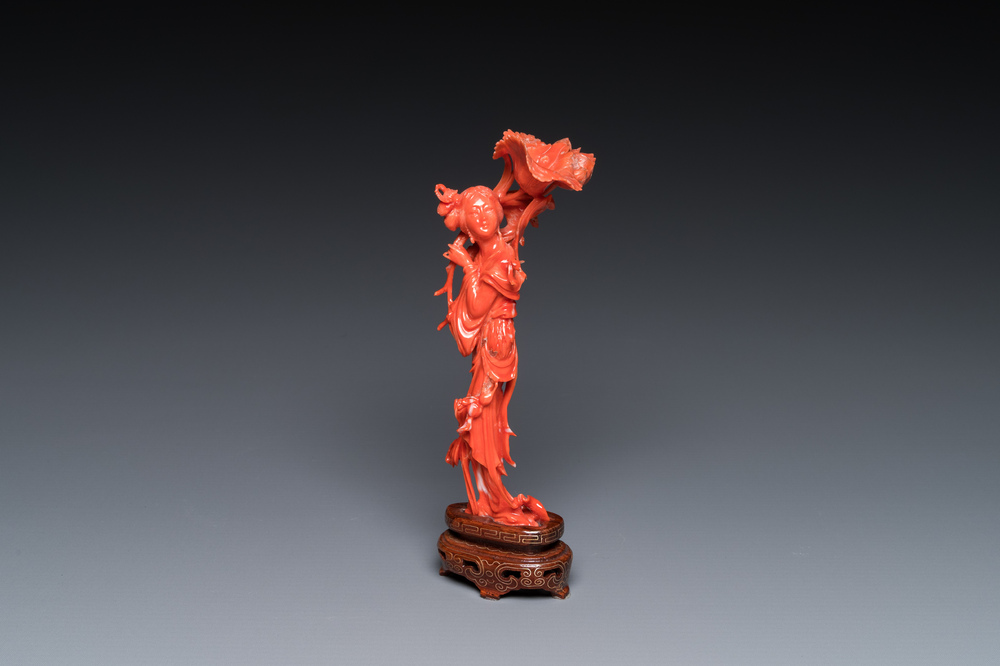 Een Chinese bloedkoralen sculptuur van een staande dame met een bloem, 19/20e eeuw