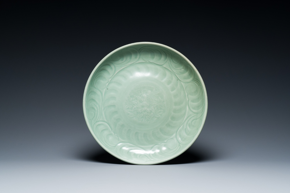 Een Chinese Longquan celadon schotel met onderglazuur decor, Ming