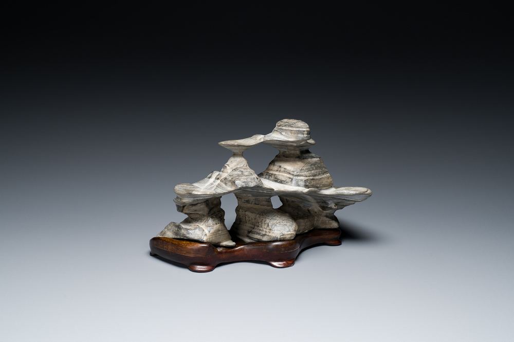 A Chinese grey lingbi stone scholar's rock on wooden stand, 19/20th C.