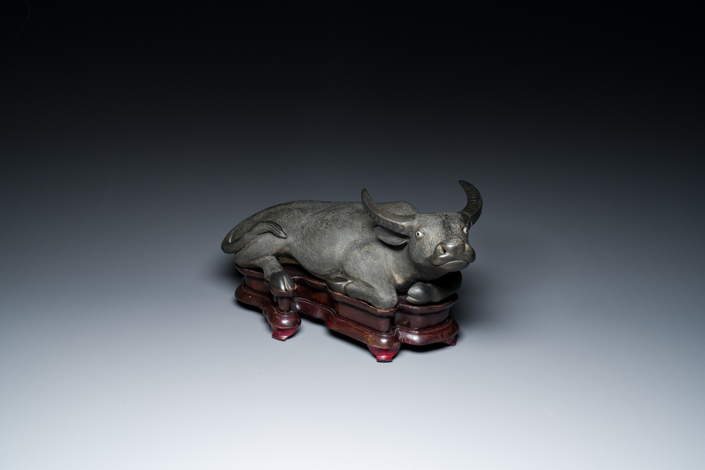 Een grote Chinese grisaille sculptuur van een liggende buffel op houten sokkel, 18/19e eeuw