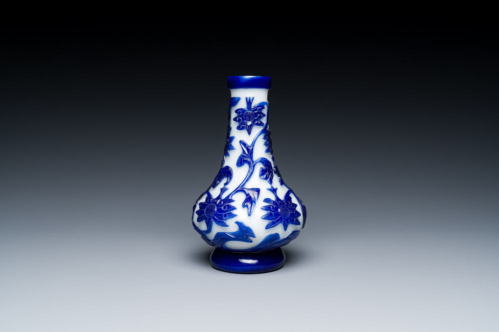 A Chinese overlay Beijing glass bottle vase with lotus scrolls in blue on white, 19th C.
