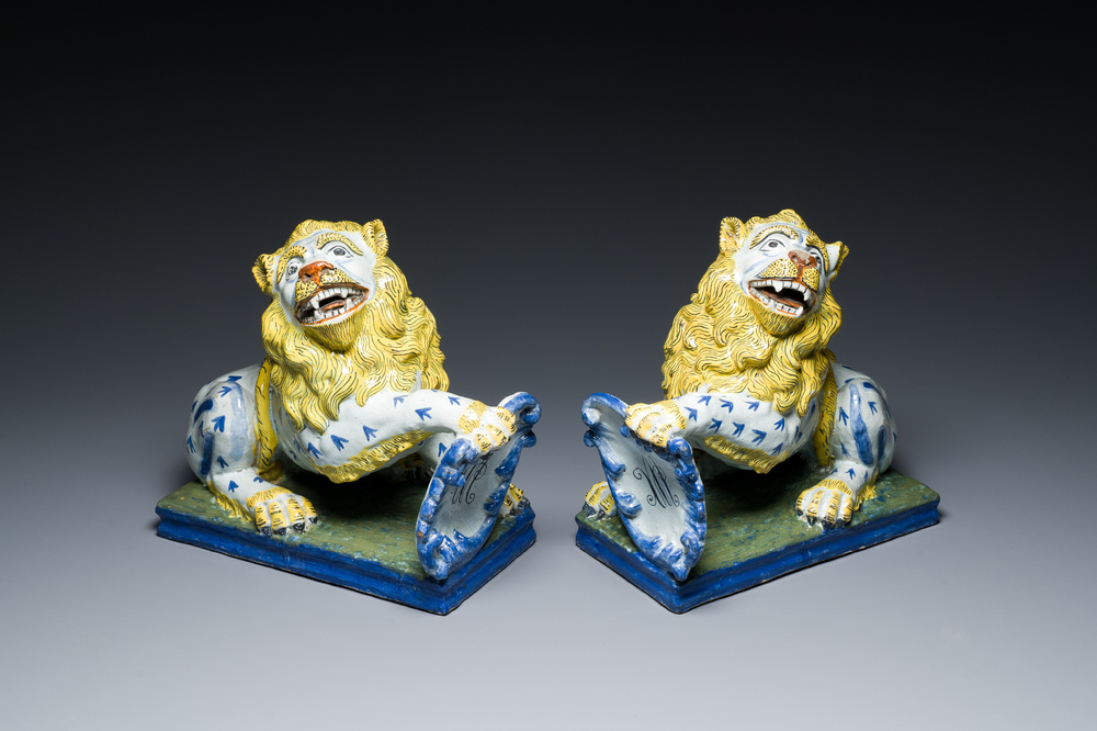 Een paar polychrome Franse aardewerken leeuwen met gemonogrammeerd schild, wellicht Rouen,18/19e eeuw