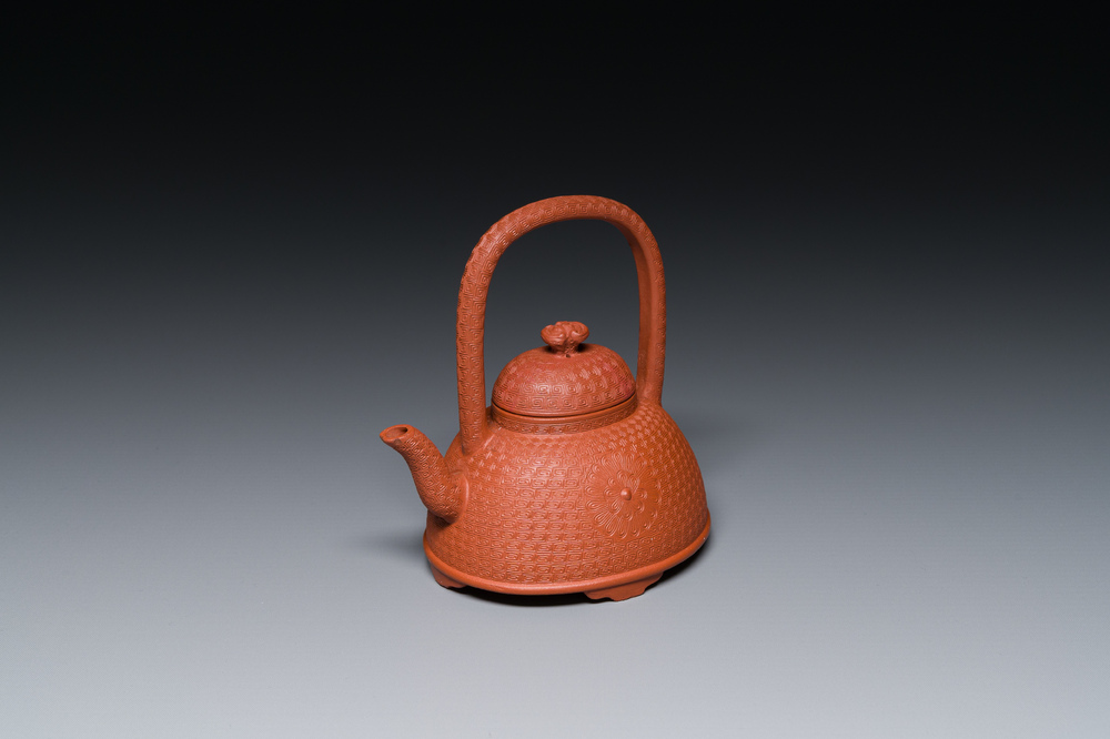 Een Chinese Yixing steengoed theepot met gekerfd decor van chrysanten, Kangxi