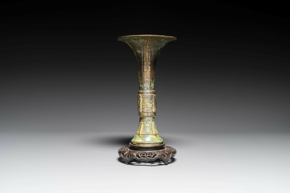 Een Chinese bronzen Shang-stijl 'gu' vaas op houten sokkel, 19/20e eeuw