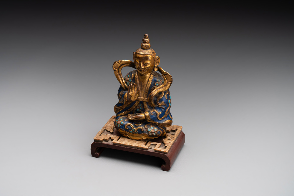 A Chinese gilt and champlev&eacute; enamelled bronze Bodhisattva on a carved stone stand, Qing