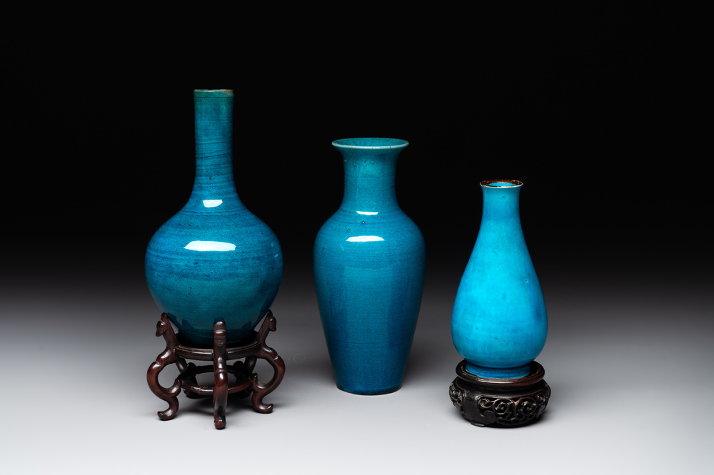 Three Chinese monochrome turquoise-glazed vases with two wooden stands, Kangxi and later