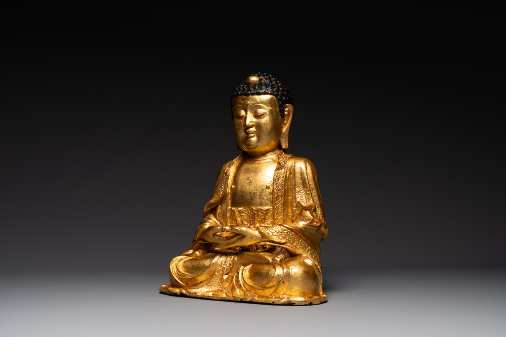 A large Sino-Tibetan gilt bronze Buddha on wooden stand, Ming