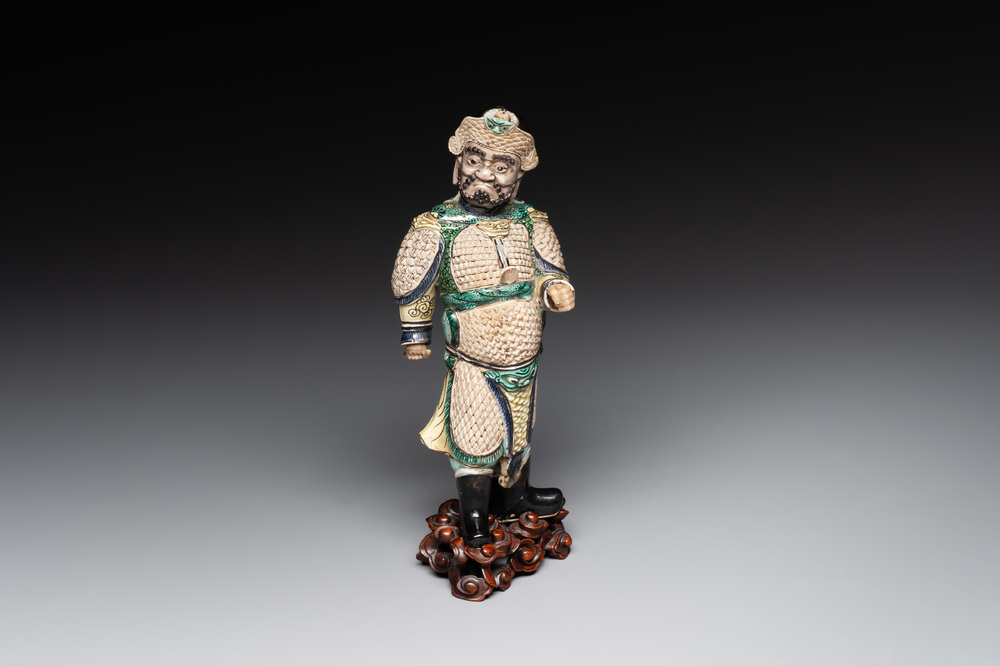 A fine Chinese verte biscuit figure of a warrior on wooden stand, Kangxi