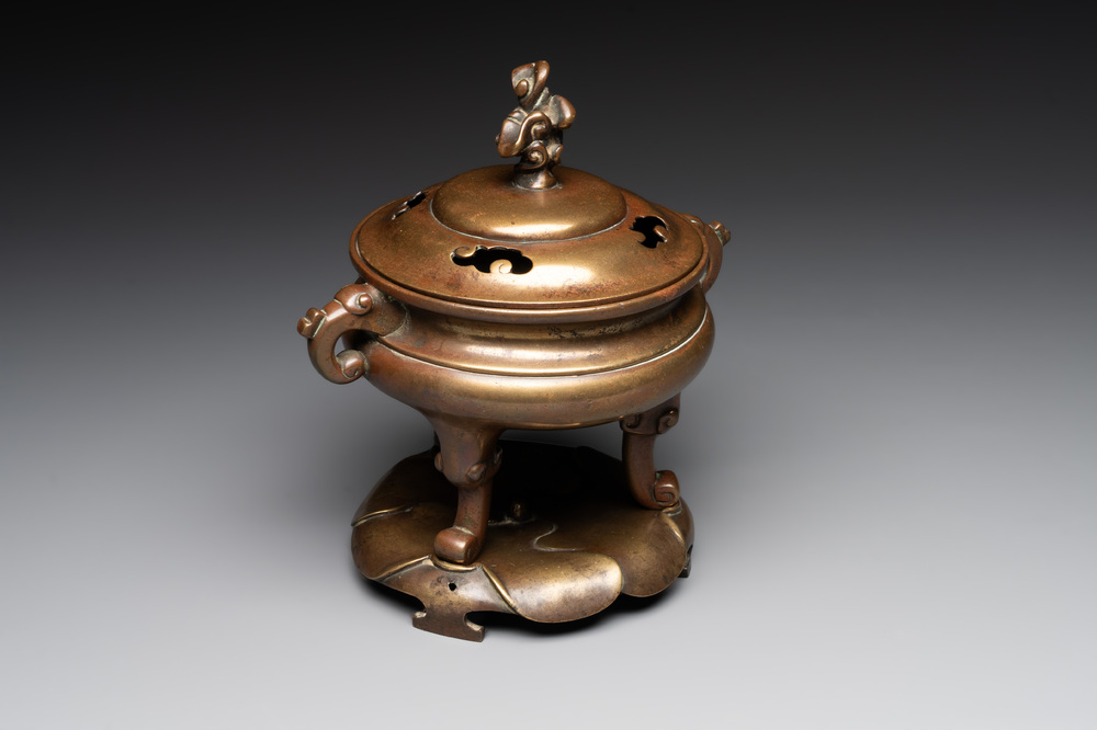 A Chinese bronze tripod censer with cover and stand, 19th C.