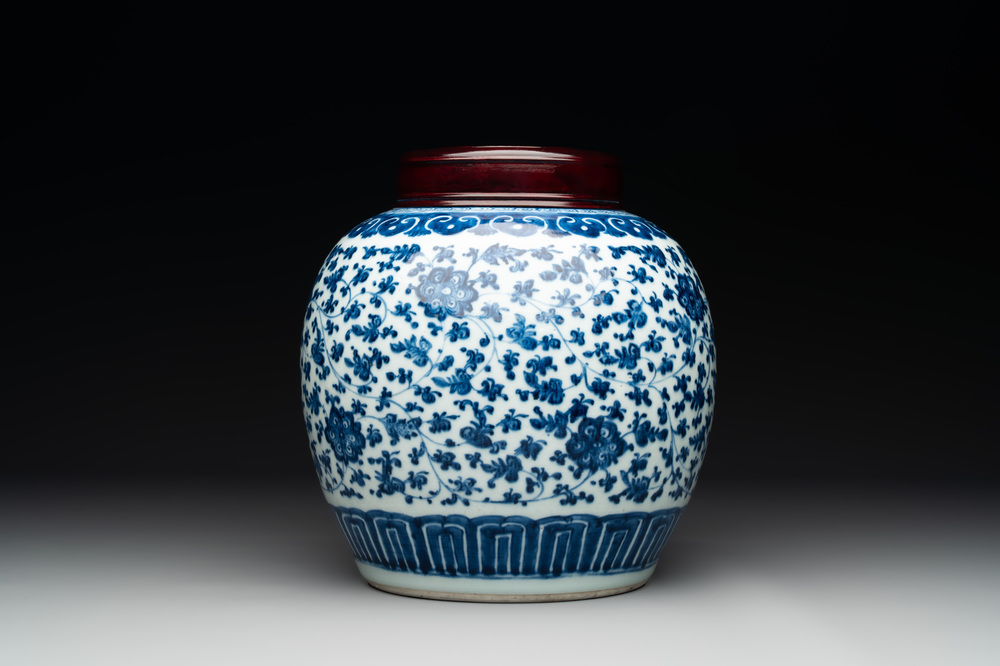 A Chinese blue and white 'flower scroll' jar with a wooden cover, Qianlong