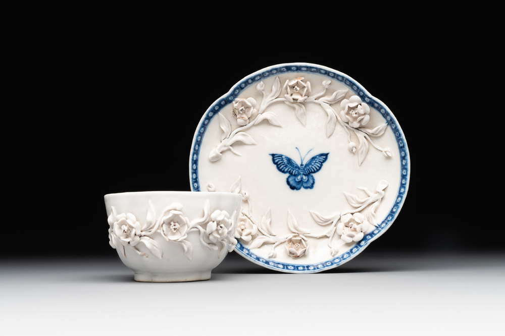A Chinese blue and white 'butterfly' cup and saucer with applied floral design, Qianlong