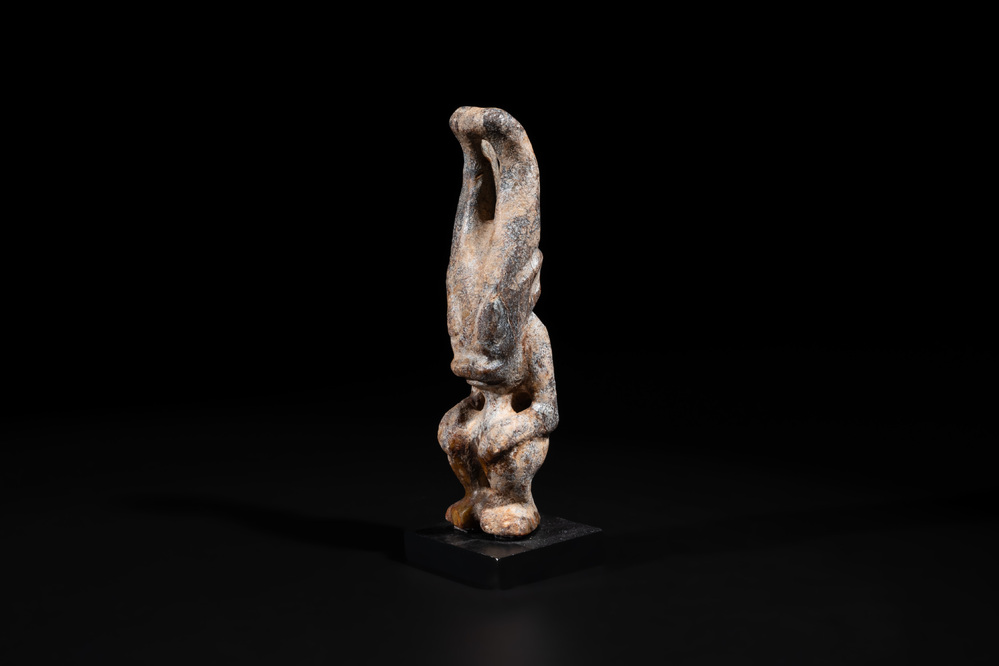 A Chinese jade carving of a crouched figure, possibly Hongshan culture