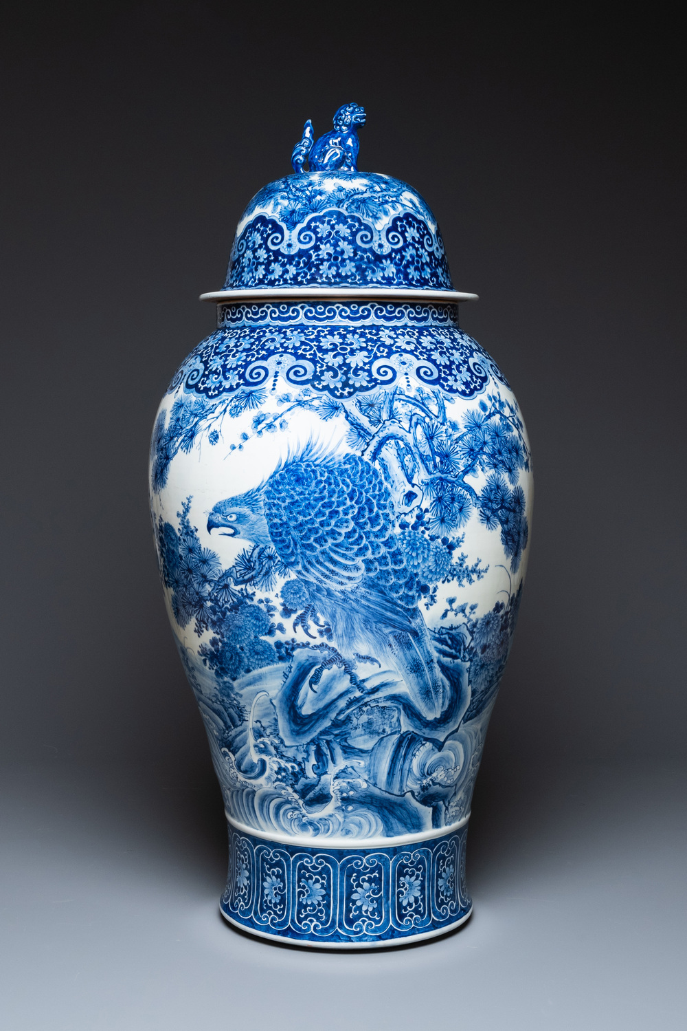 A massive Japanese blue and white Arita vase and cover with an eagle, a shishi and cub, 19th C.