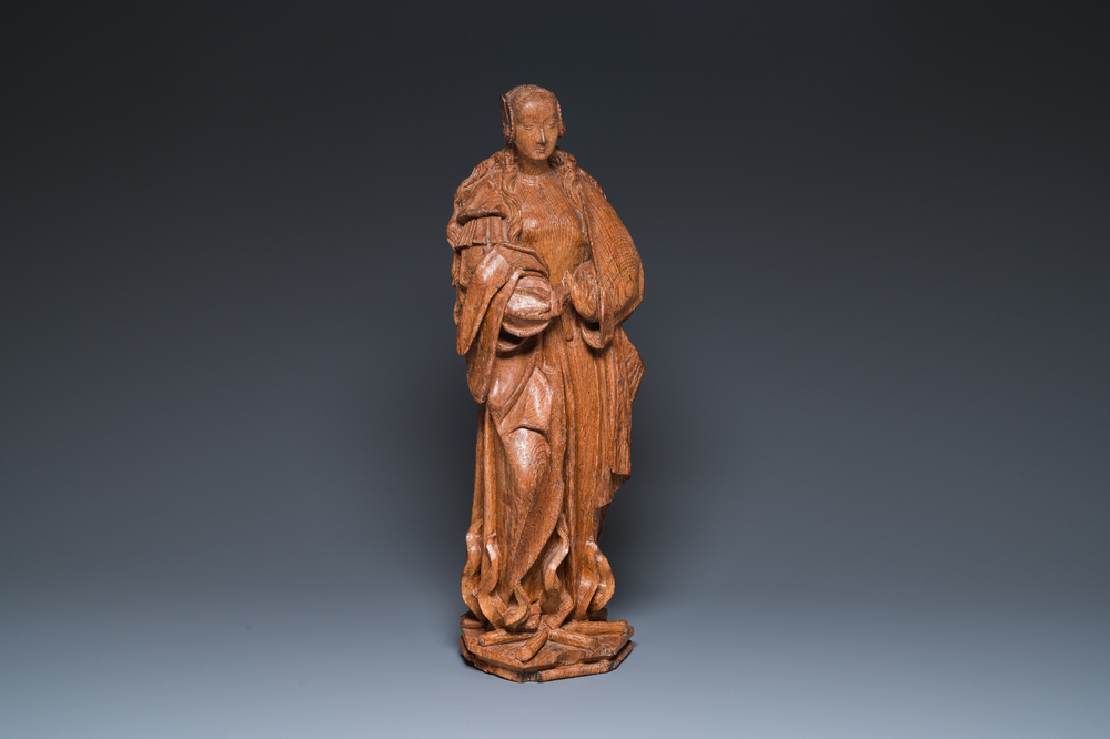 A Flemish late gothic carved oak sculpture of Saint Thecla on a pyre, Brabant region, first half 16th C.