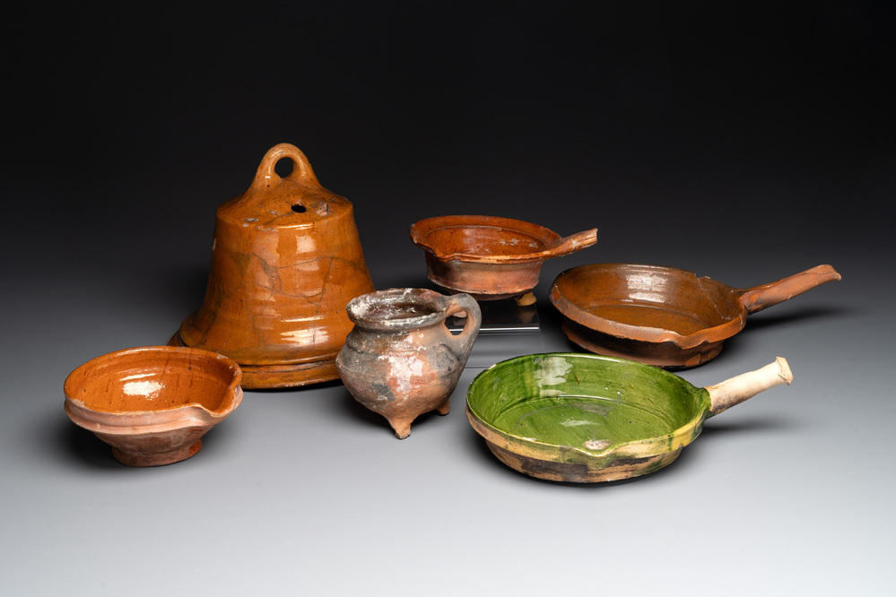 Five pieces of glazed earthenware cooking utensils and a fire bell, probably The Netherlands, 17th C.
