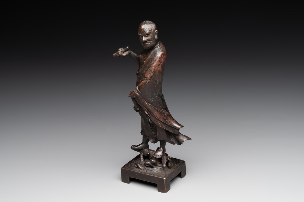 A fine Chinese bronze Luohan holding a sutra, Ming