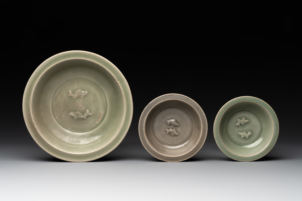 A Chinese Longquan celadon 'twin fish' dish and two 'twin fish' saucers, Yuan/Ming