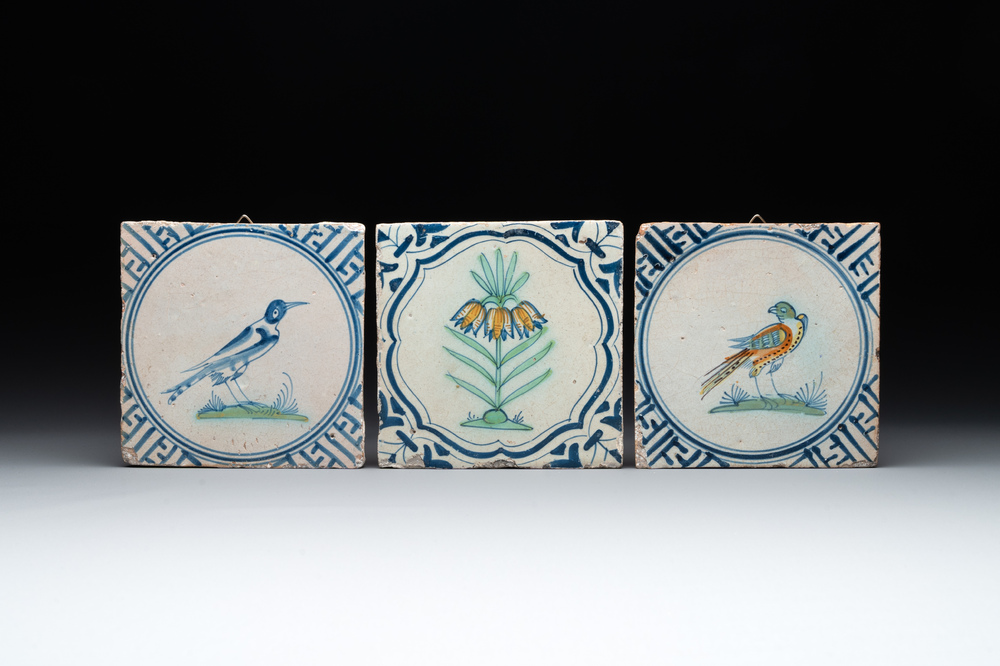 Three polychrome Dutch Delft tiles with birds and a flower, 17th C.