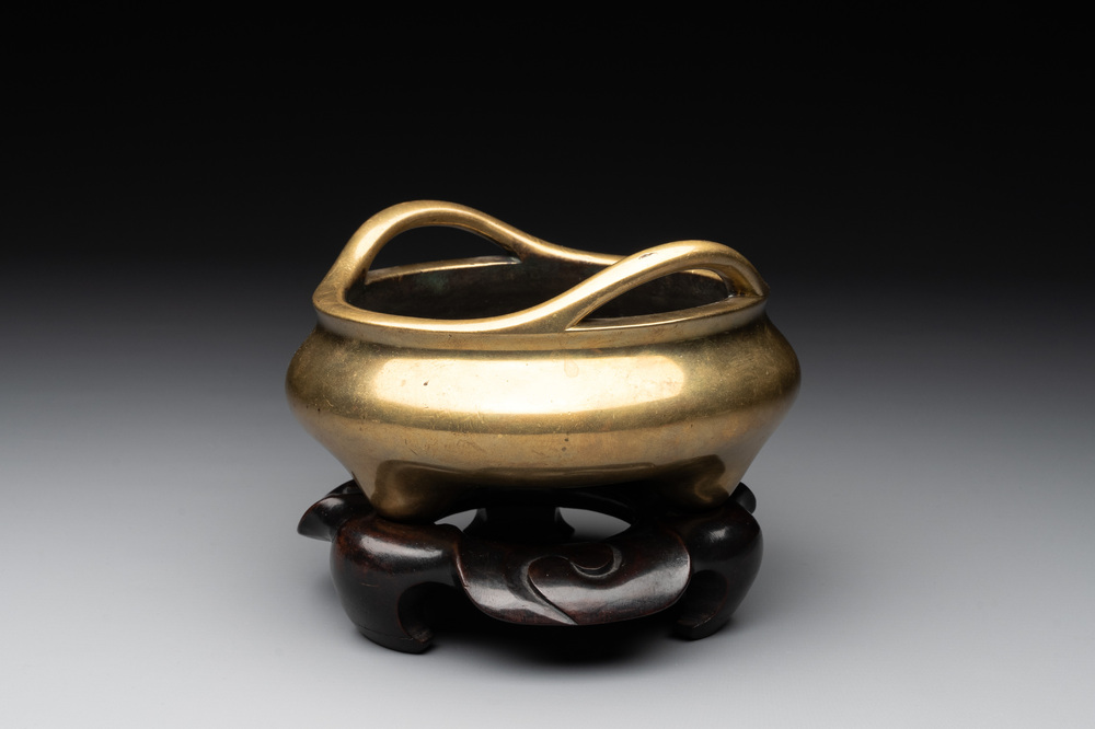 A Chinese bronze tripod censer on a wooden stand, Song Zhu Xuan 松竹軒 mark, 18th C.