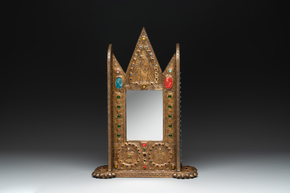 Alfred Daguet (Paris, 1875-1942): A Gothic Revival repouss&eacute; brass and copper-mounted mirror with glass cabochons, signed and dated 1907