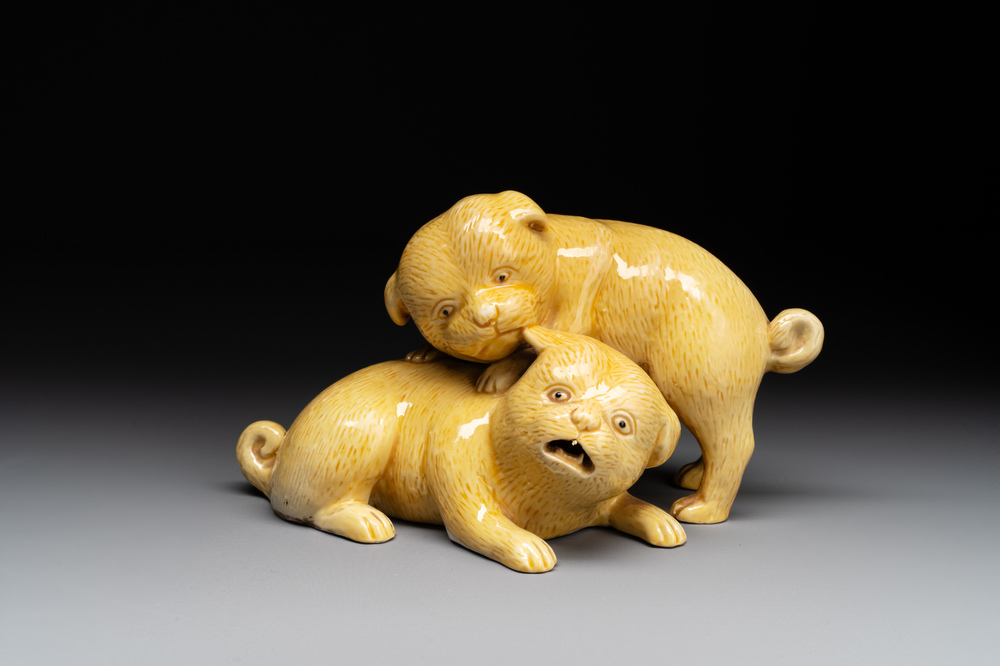 A Japanese monochrome yellow-glazed 'two playing dogs' group, 19th C.