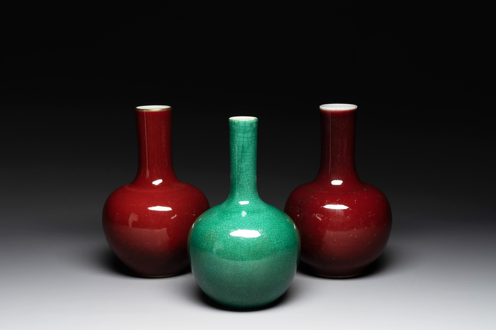A Chinese apple-green-glazed and two copper-red-glazed bottle vases, Kangxi mark, 19/20th C.