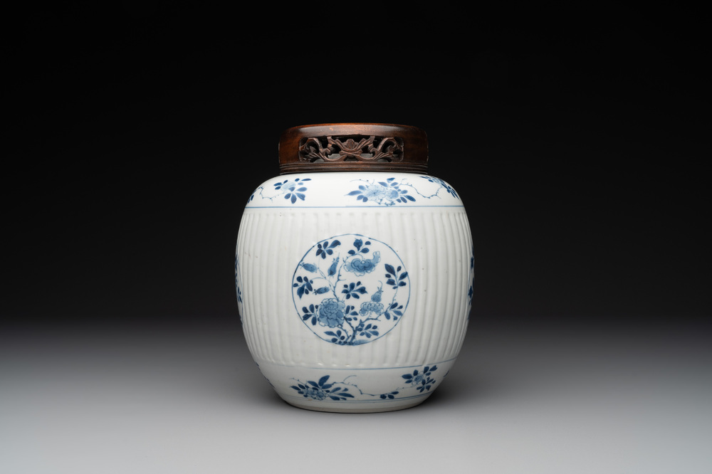 A Chinese blue and white jar with floral design and a wooden cover, Kangxi